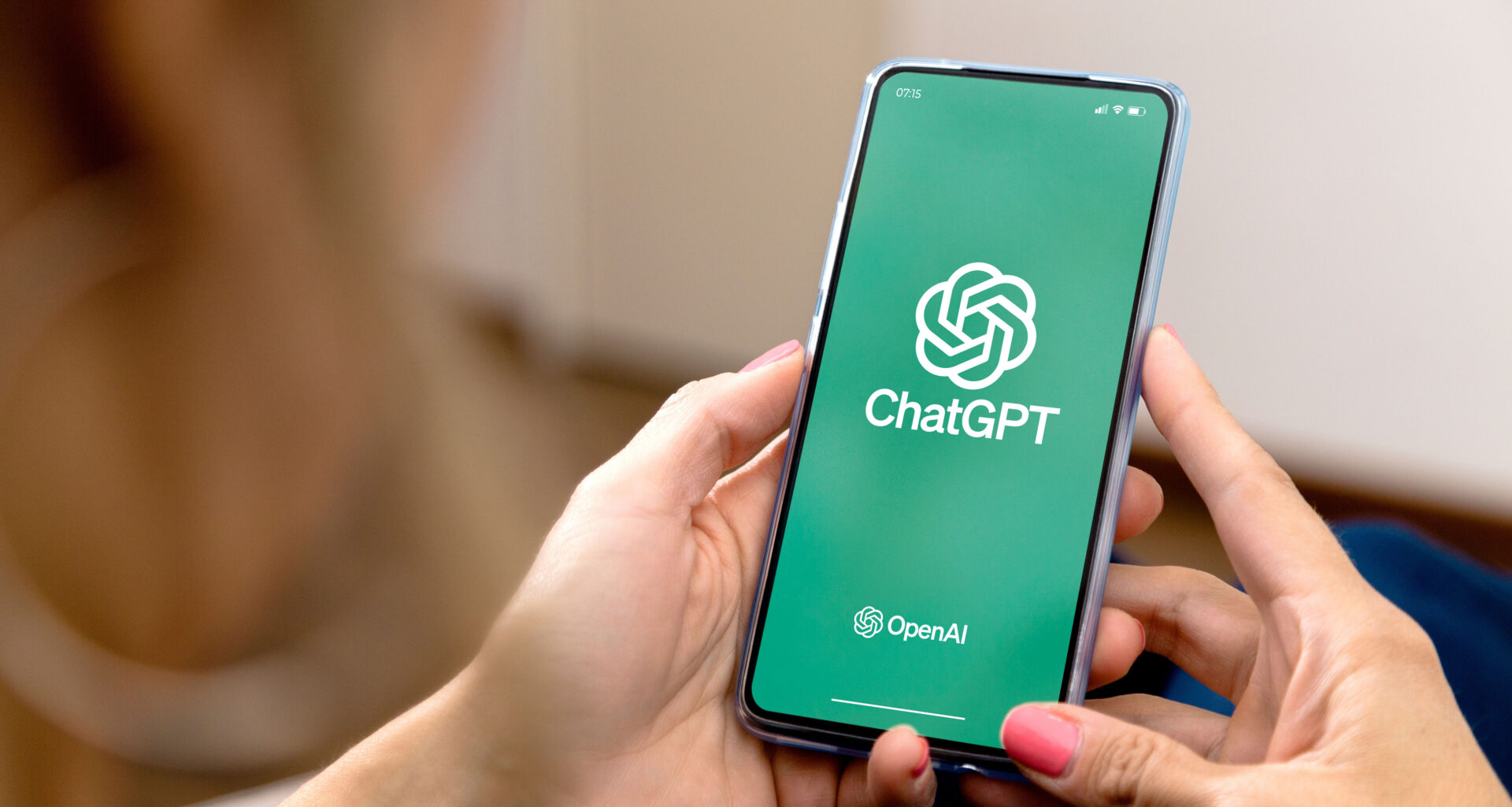 Woman using a mobile phone with ChatGPT on the screen.