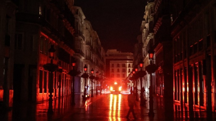 A car drives down a dark street during a blackout in Spain