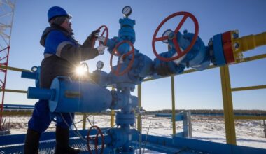 Worker turns a valve wheel at a gas well in Russia