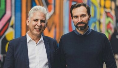 Robin Tuluie, left, and Jacomo Corbo standing in front of a colourfully painted wall