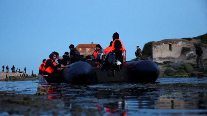 An inflatable dinghy prepares to set out into the English Channel from Ambleteuse, near Calais