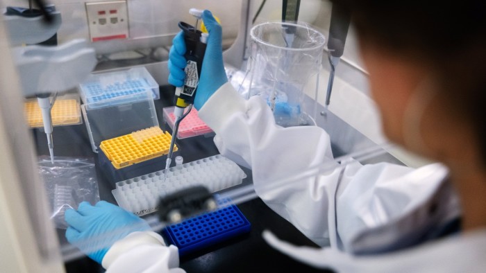 A researcher in a laboratory uses genome sequencing equipment