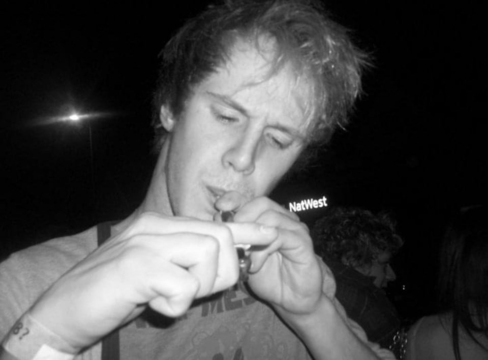 Black and white photo of a young man smoking.