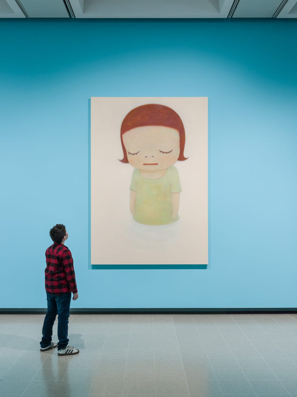 Child observing a painting in an art gallery