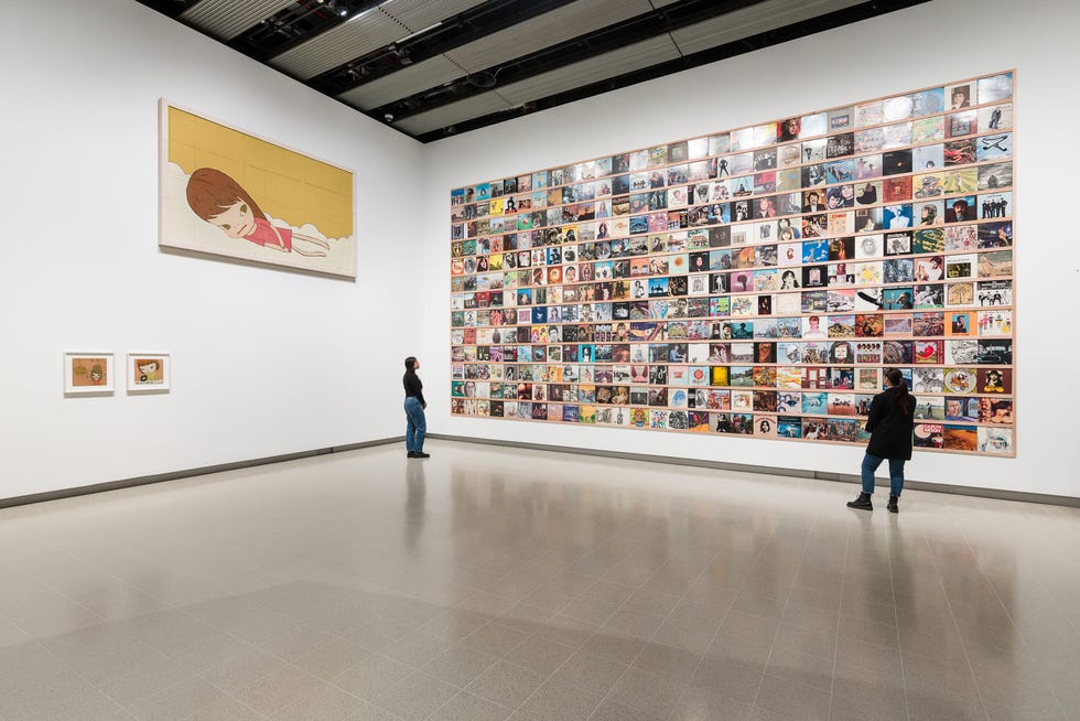 Art gallery with wallmounted artwork and visitors observing