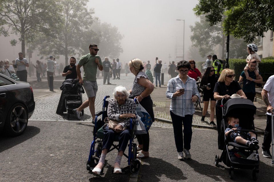 People watching a controlled demolition of tower blocks.