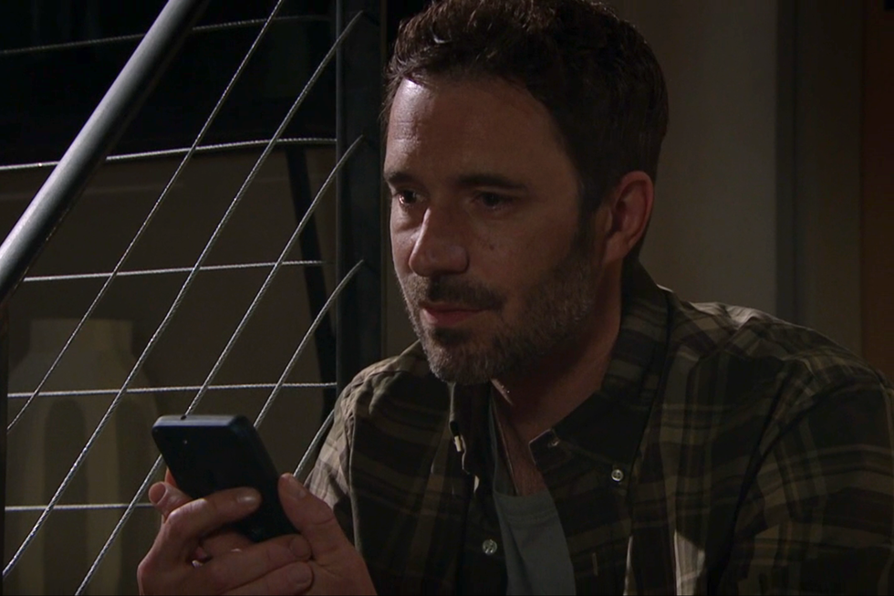 john sugden holds his phone in his hands, emmerdale