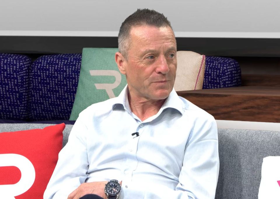 Man in light blue shirt sitting on a couch.
