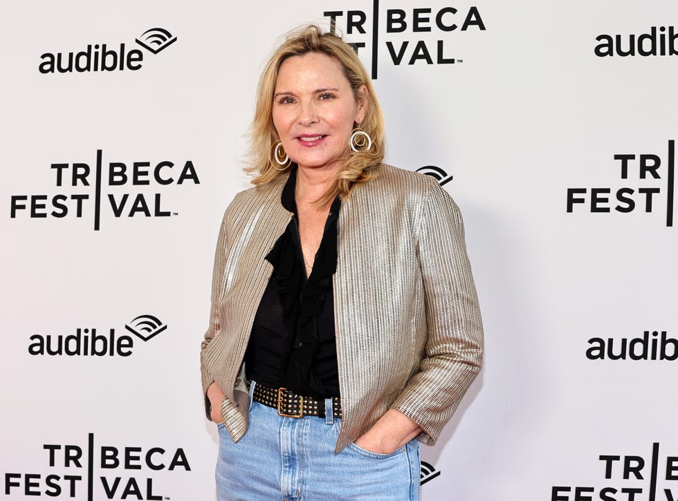 kim cattrall wearing a black blouse and metallic blazer, smiling on the red carpet at the 2023 tribeca festival