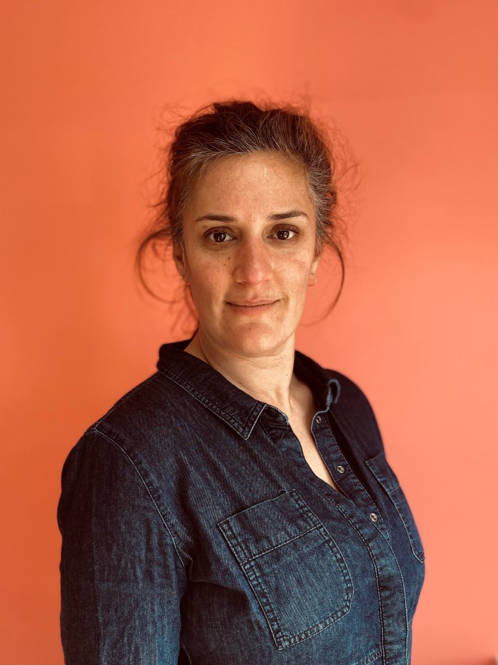 Portrait of a woman wearing a denim shirt.