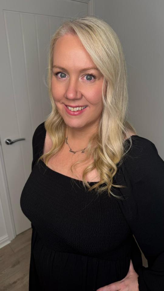 Woman with blonde hair wearing a black dress.
