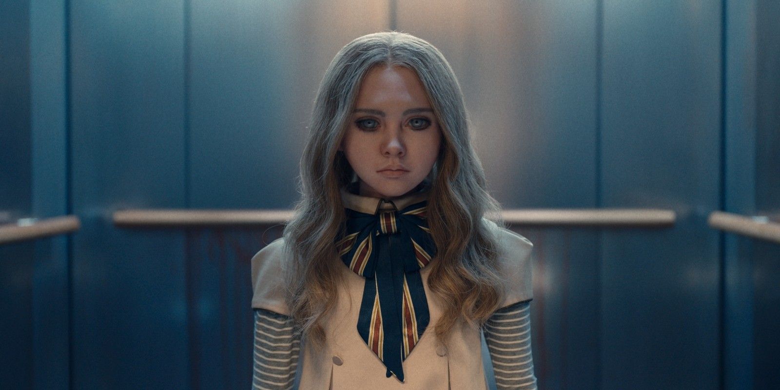 M3GAN staring toward the camera with her back towards an elevator in M3GAN