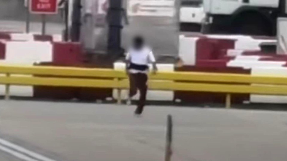 A man running on an airport tarmac being chased by several other men.