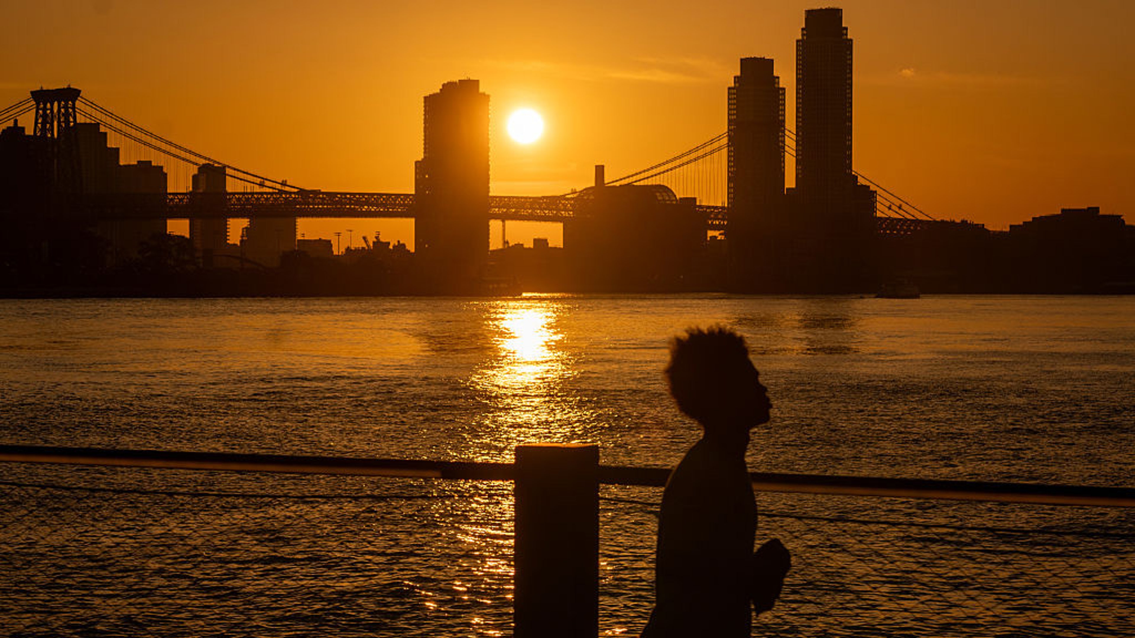 NEW YORK CITY - JUNE 24: The sun rises over Manhattan on what is expected to be the hottest day of the year on June 24, 2025 in New York City. Temperatures in New York City are expected to reach into the high 90's with a heat index of over 100 degrees as 