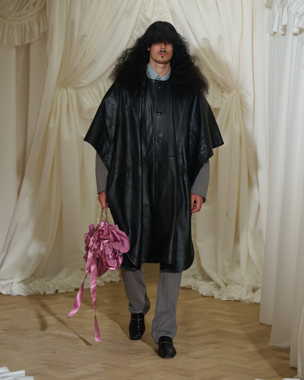 a person walks confidently in a fashionforward outfit with an oversized leather outer garment