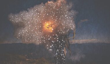 small holes pierce a dark photo of a person holding fire
