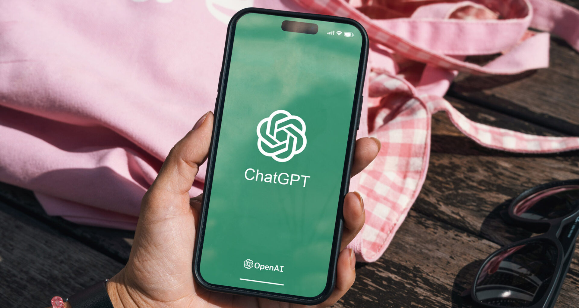 Holding phone with ChatGPT logo