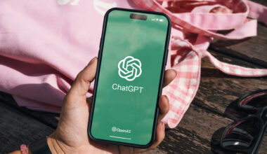 Holding phone with ChatGPT logo
