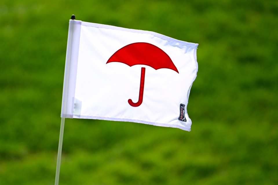 Golf course pin flag with a red umbrella logo.