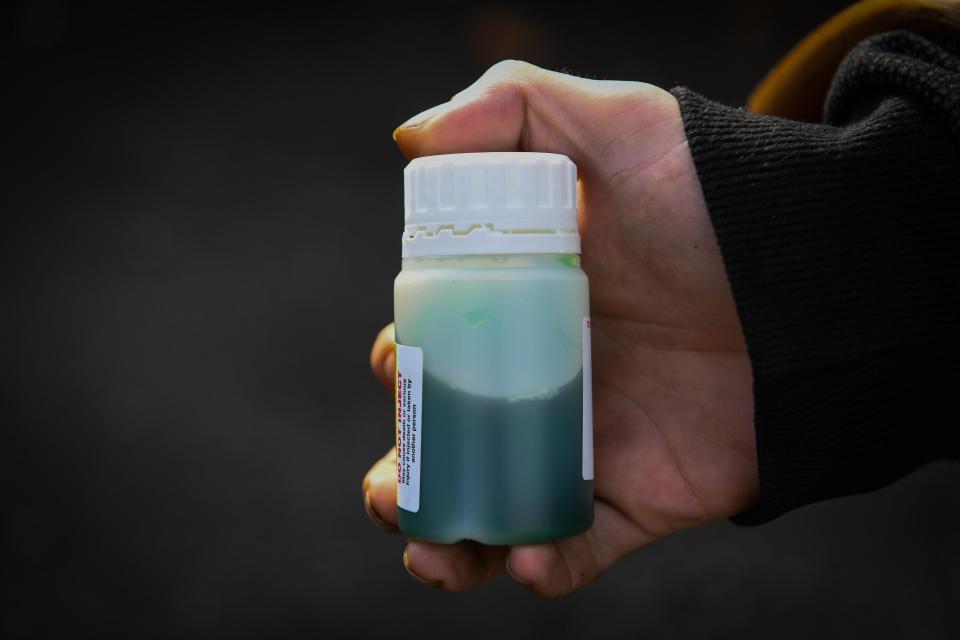 Hand holding a bottle of methadone.