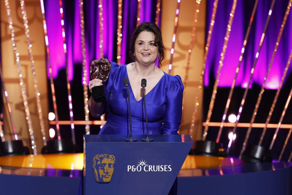 ruth jones giving a speech on stage while collecting her bafta award