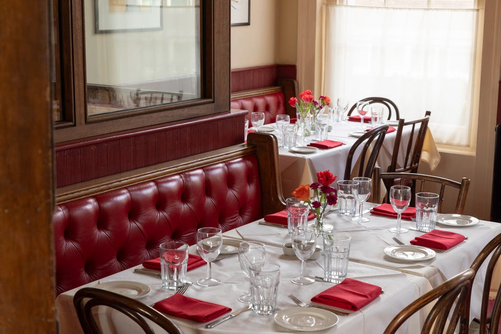 the interior of a pub with white table clothes on tables