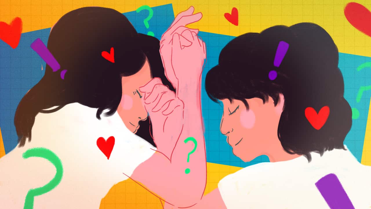 A vibrantly coloured illustration of a couple in bed, holding hands and surrounded by illustrated hearts, question marks and exclamation marks.