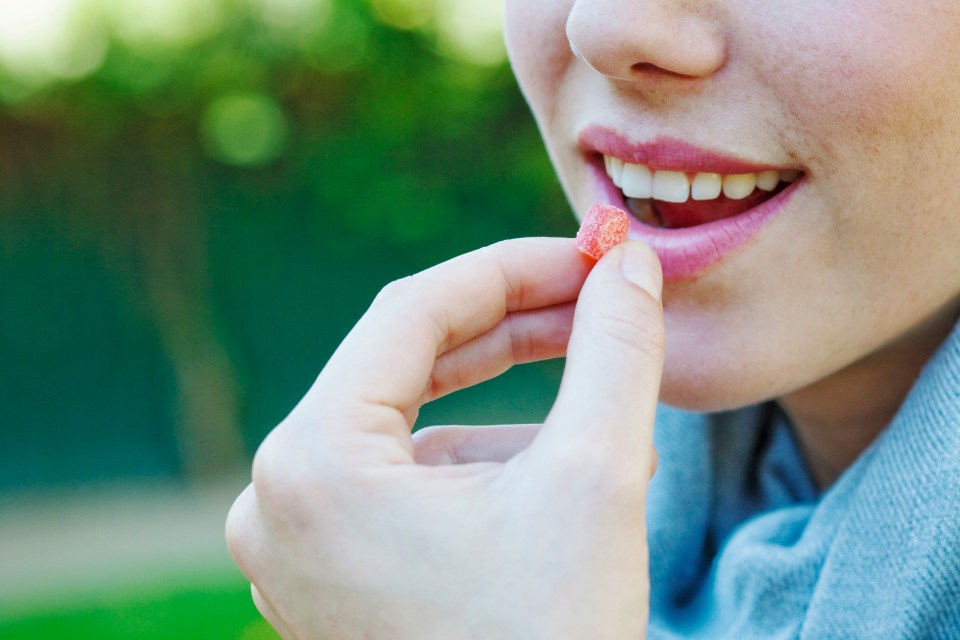 Close-up of a young woman taking medication.