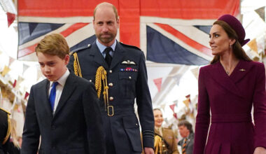 Kate Middleton looks at Prince William, who is wearing military uniform in front of the British flag, while Prince George walks with his head down