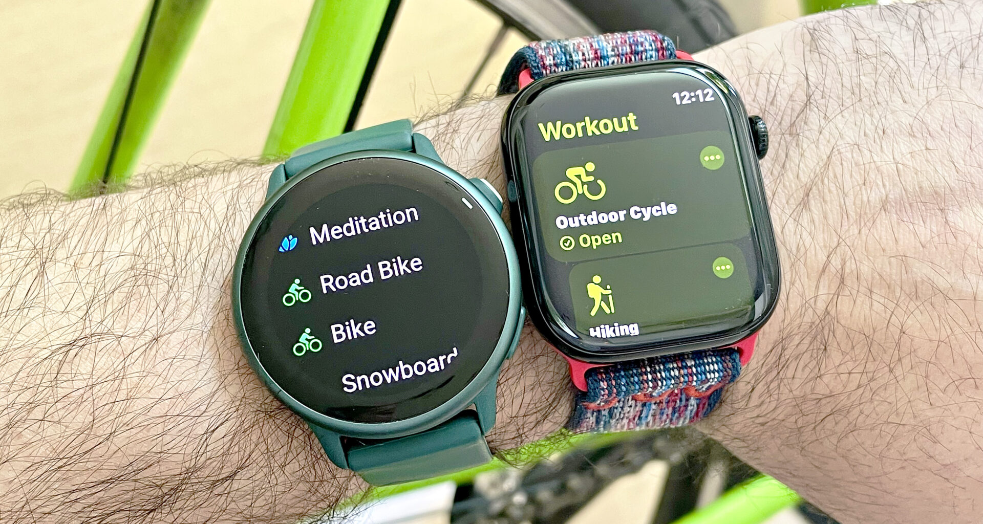 Close-up of a user's wrist wearing both the Apple Watch 10 on a multi-colored fabric strap (right) next to the Garmin Vivoactive 6 (left) on an emerald green strap