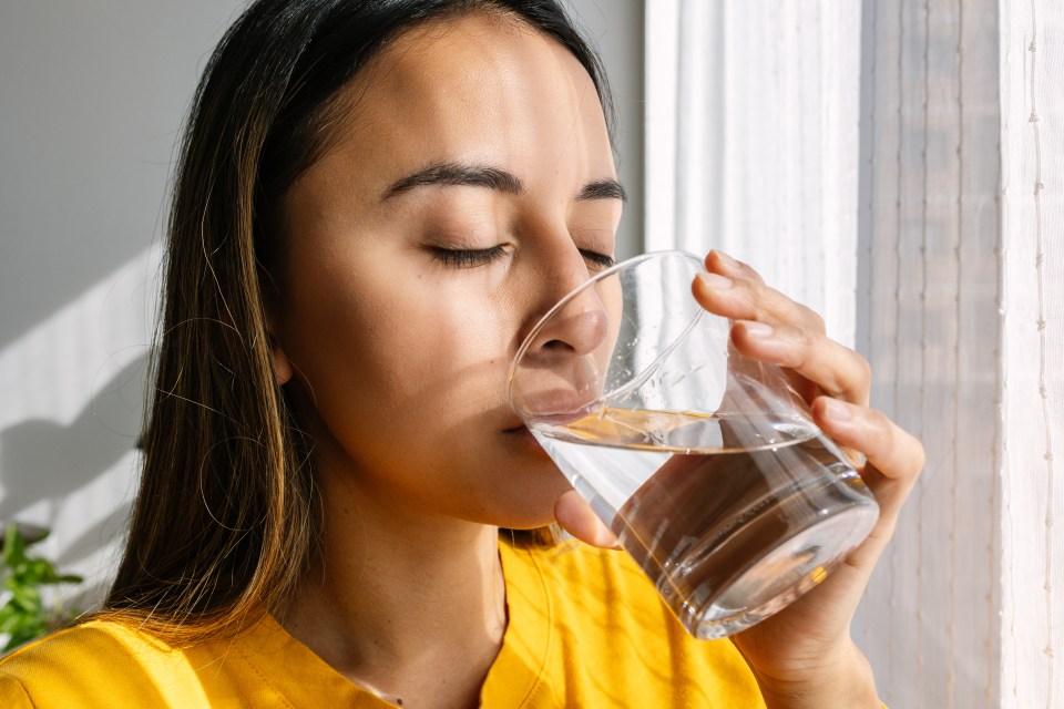 Young woman drinking water.