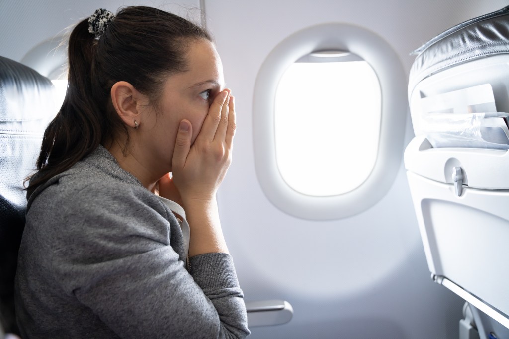 A woman panicking on a plane.
