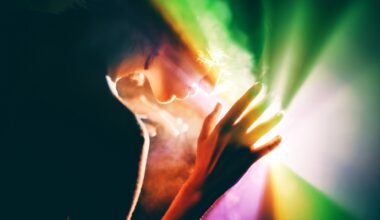 a photograph of a woman holding her hand up to a rainbow light