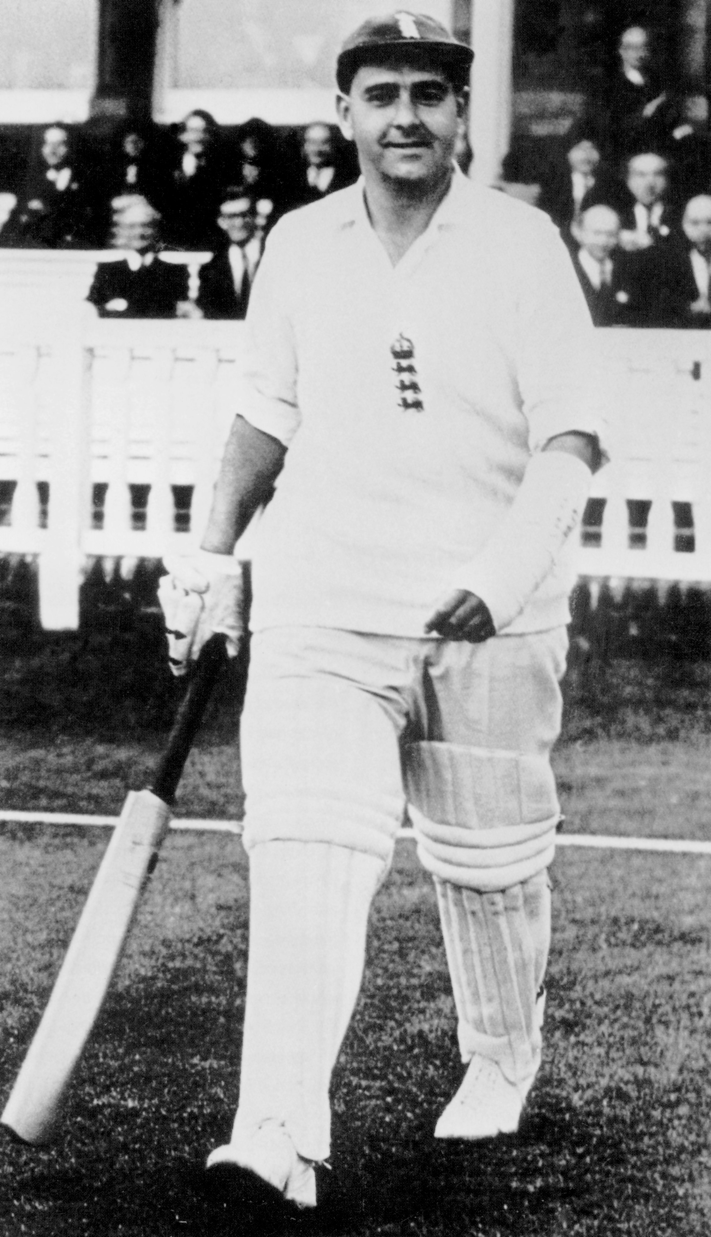 Colin Cowdrey walking onto the cricket pitch with a broken arm.