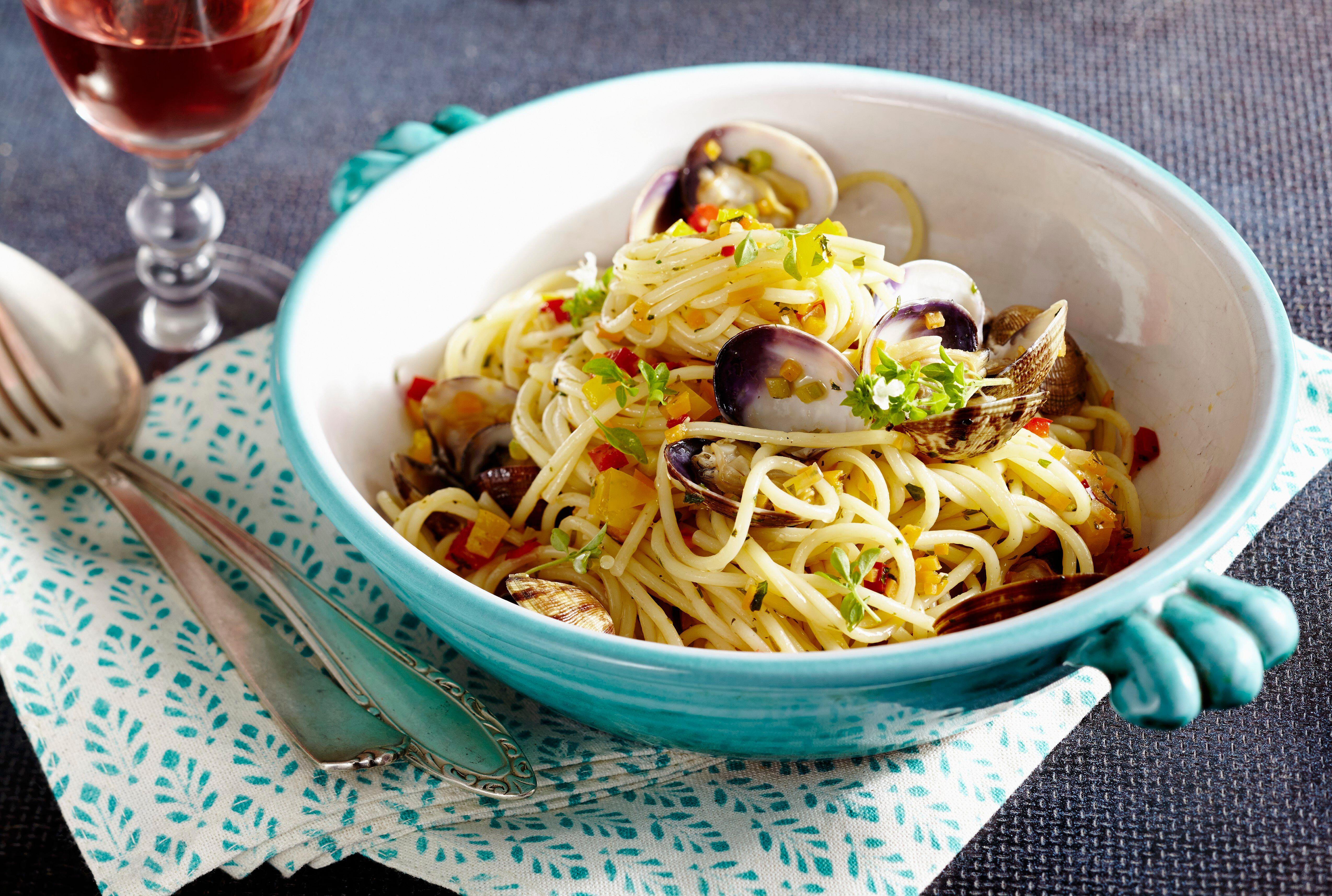 Spaghetti alle vongole in a teal bowl.