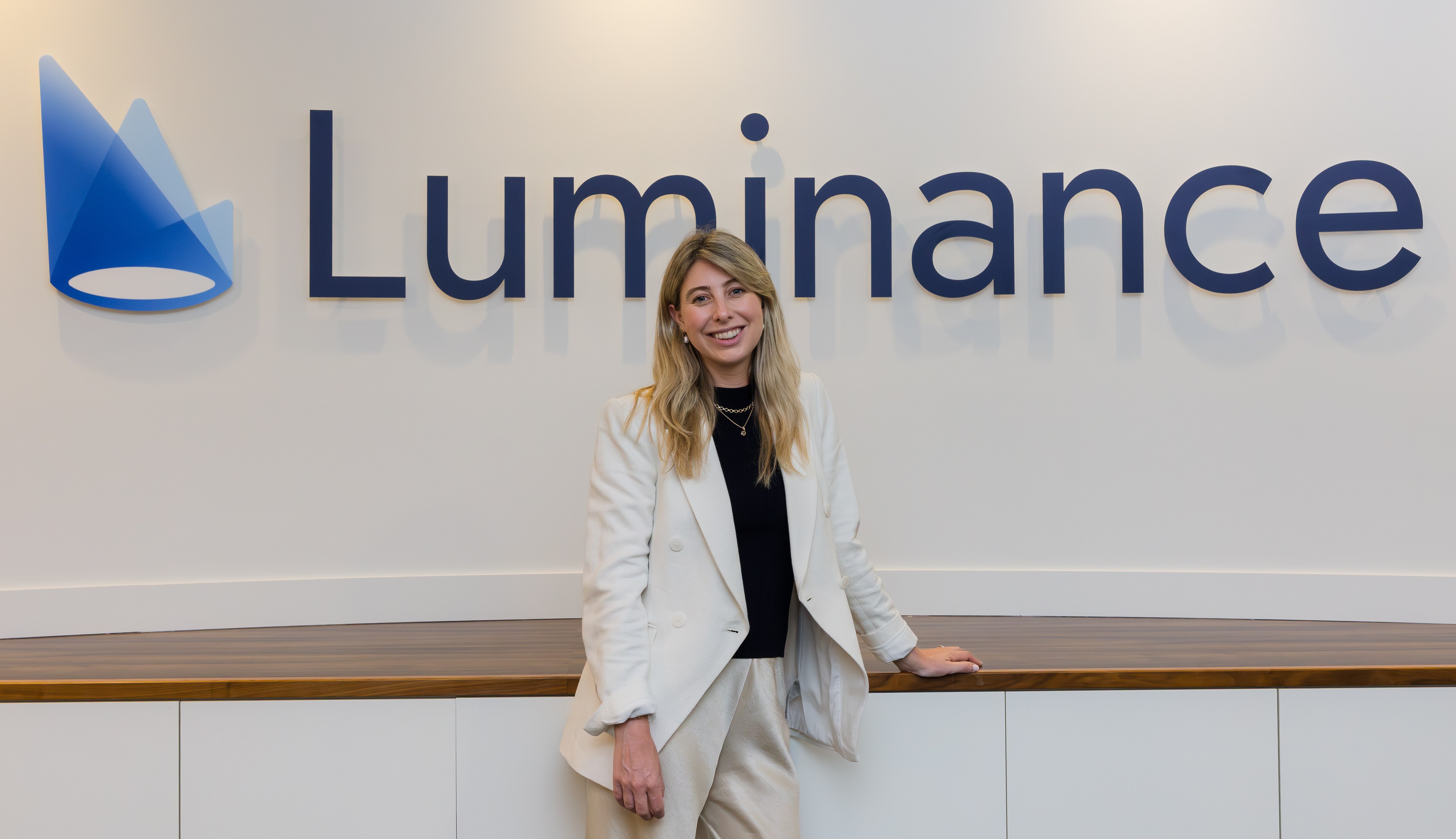 Eleanor Lightbody, CEO of Luminance, standing in front of the company logo.