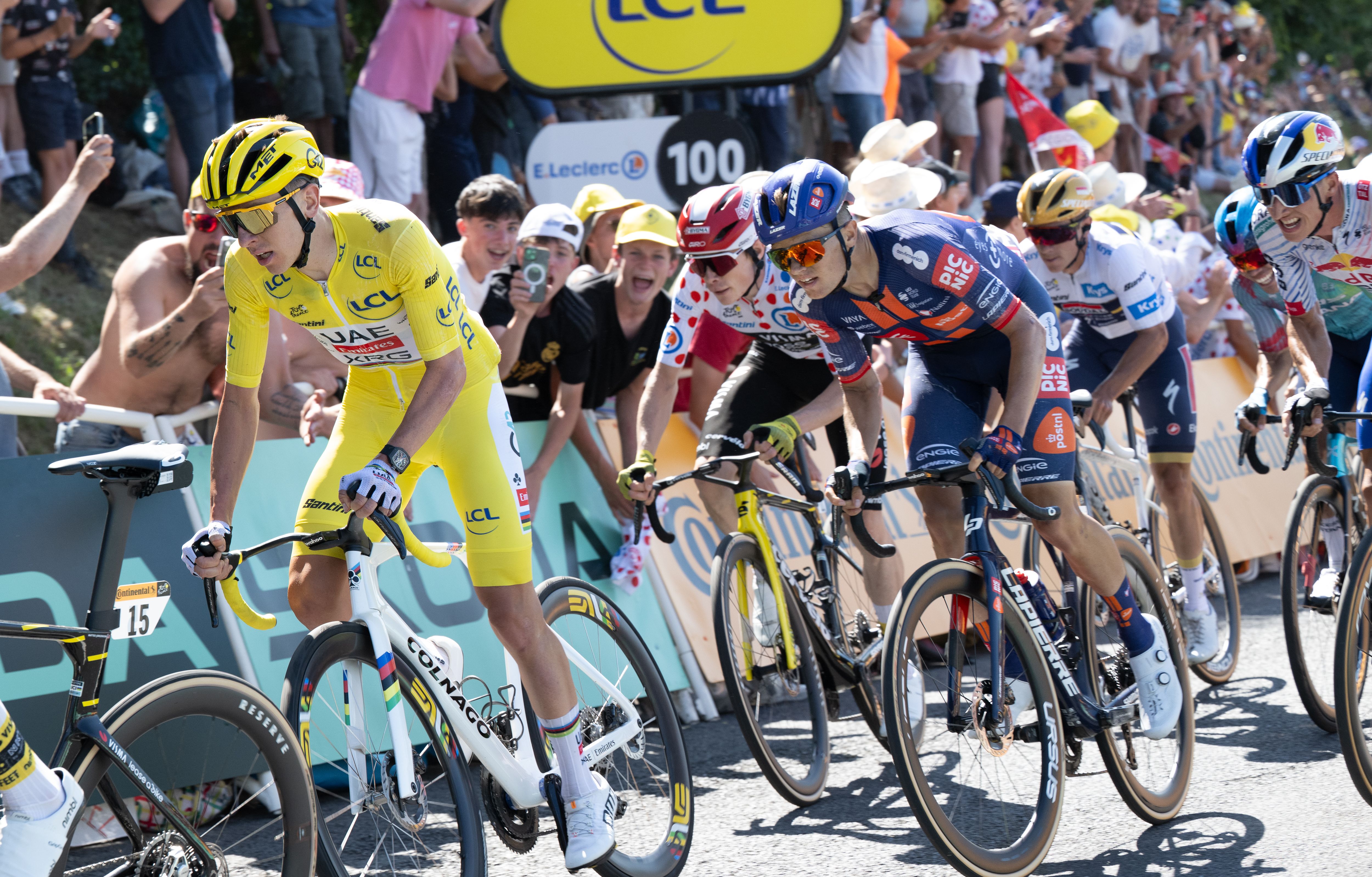 Tadej Pogačar in the yellow jersey leading a cycling race.
