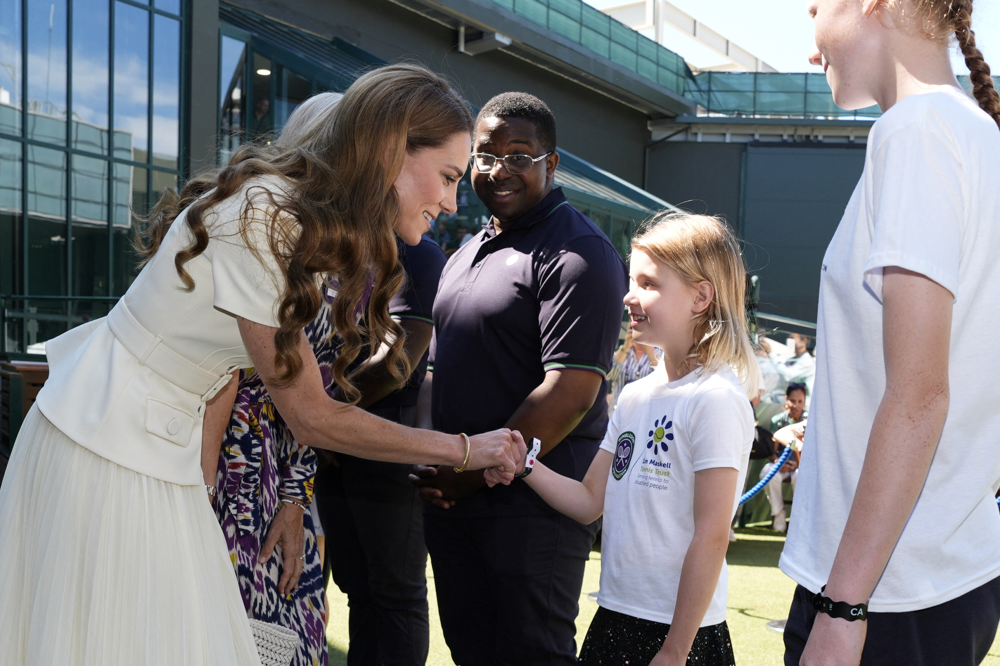 Catherine, Princess of Wales, meets a young girl at Wimbledon.