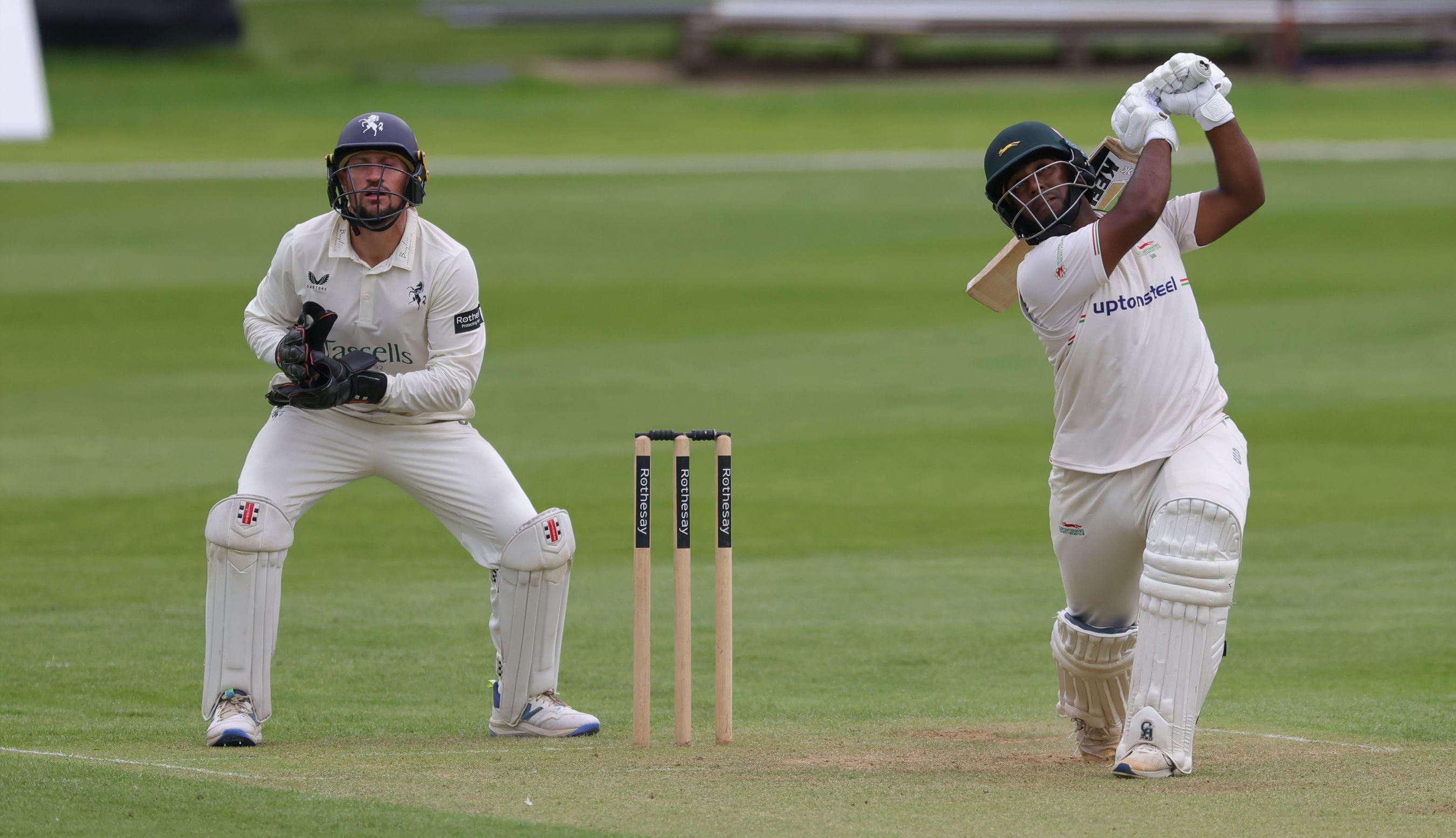 Cricket player batting, wicket-keeper watching.