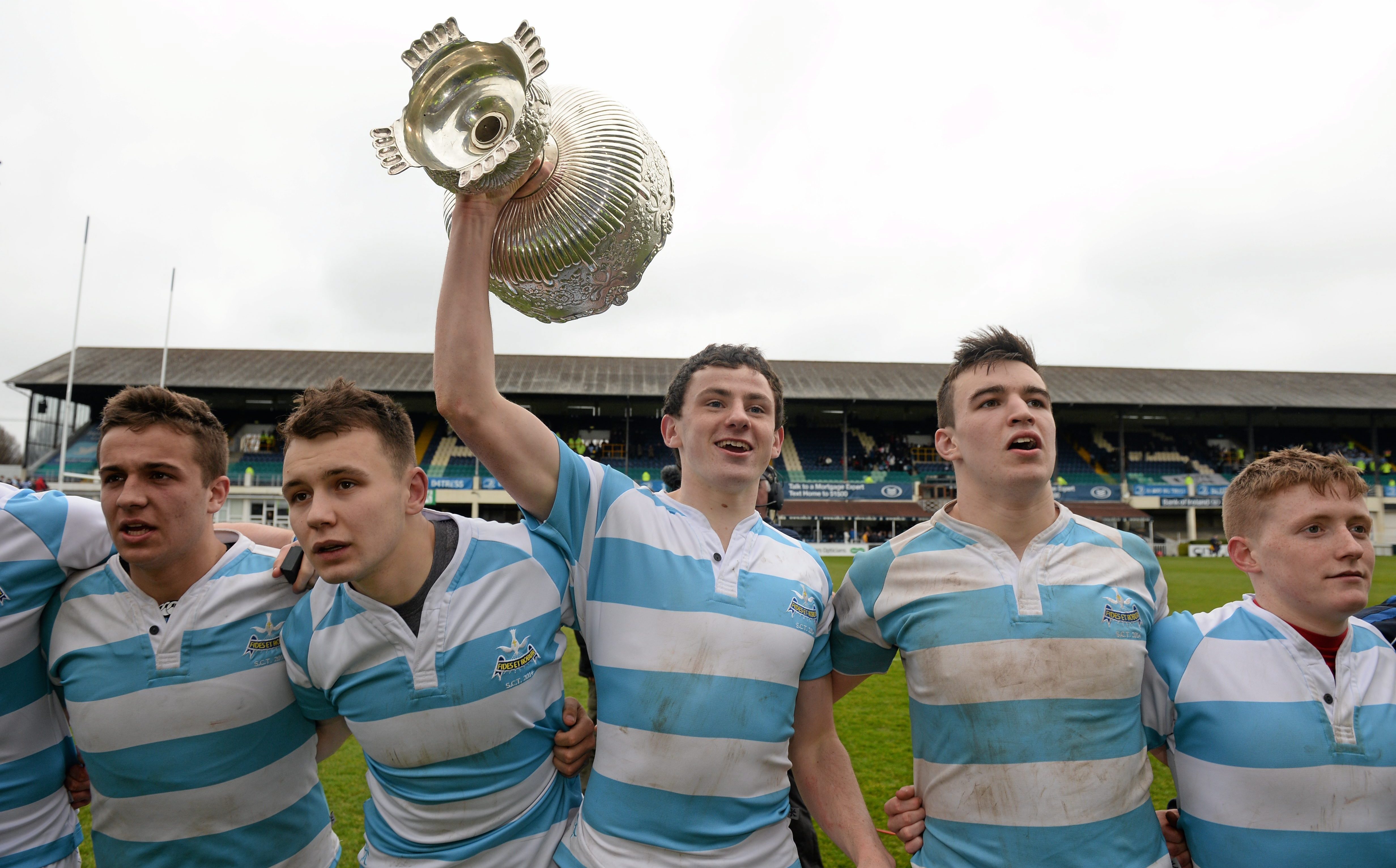 Rugby players celebrating with a trophy.