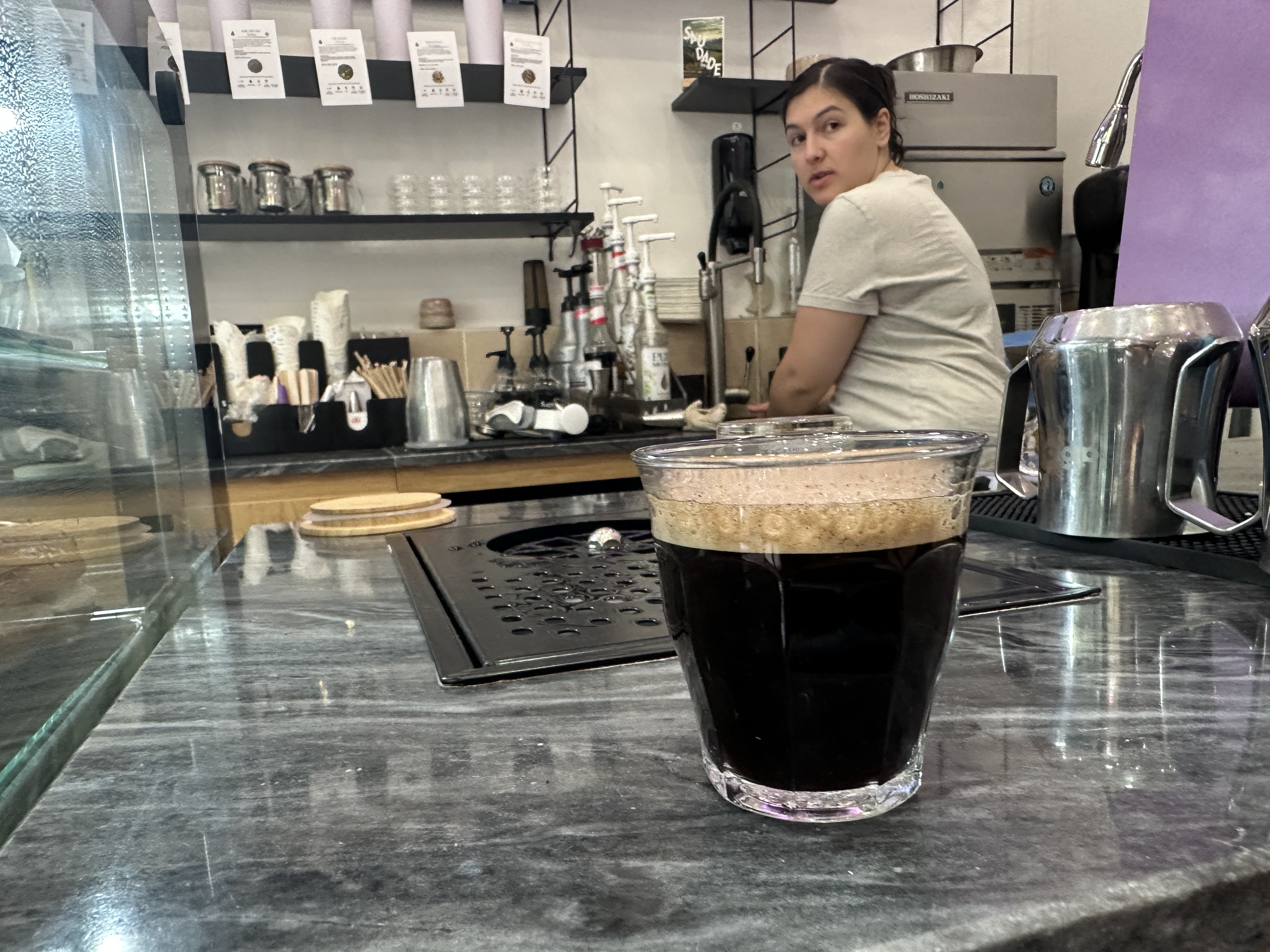 Glass of coffee on a cafe counter.