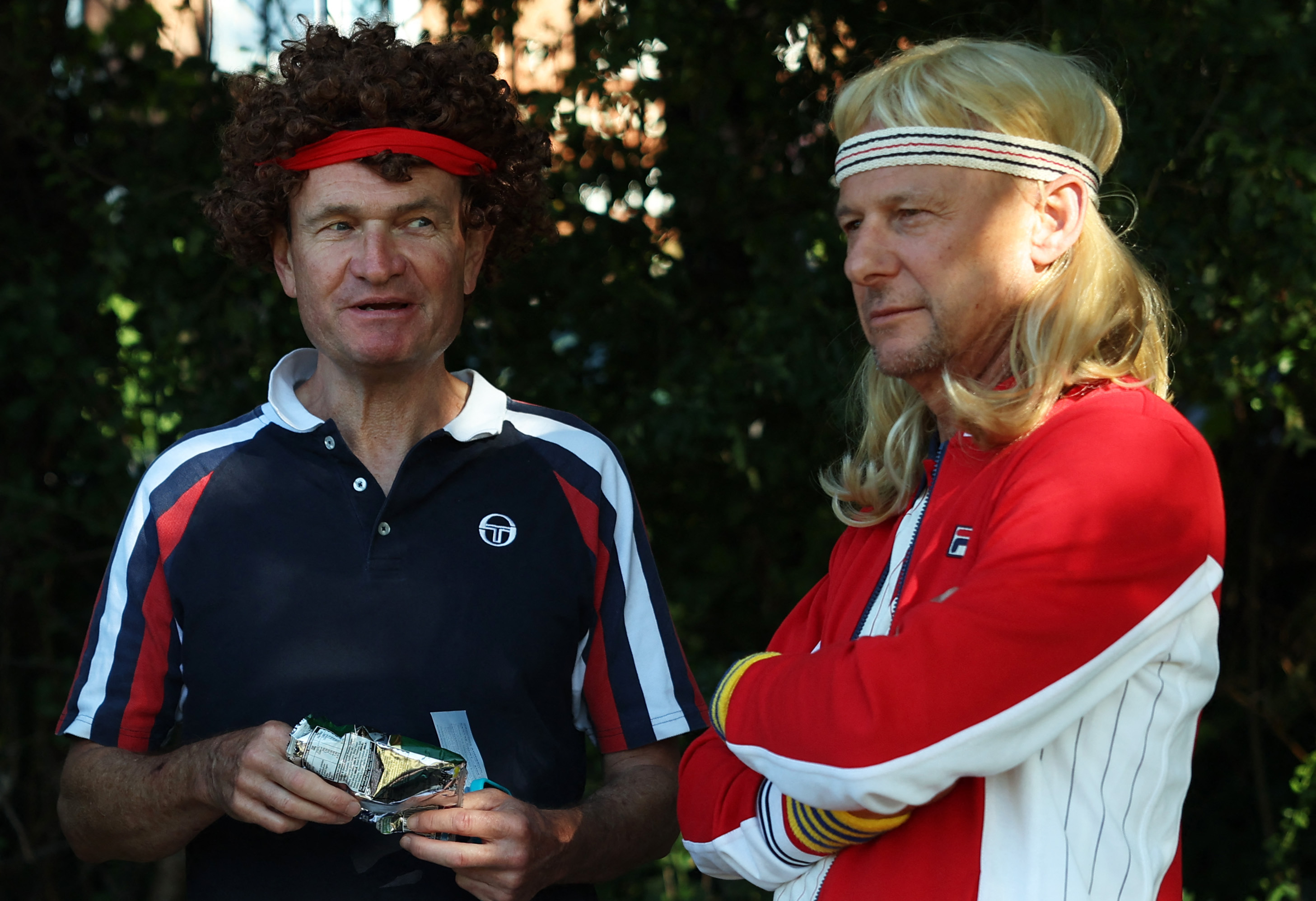 Two men dressed as John McEnroe and Bjorn Borg queue at Wimbledon.