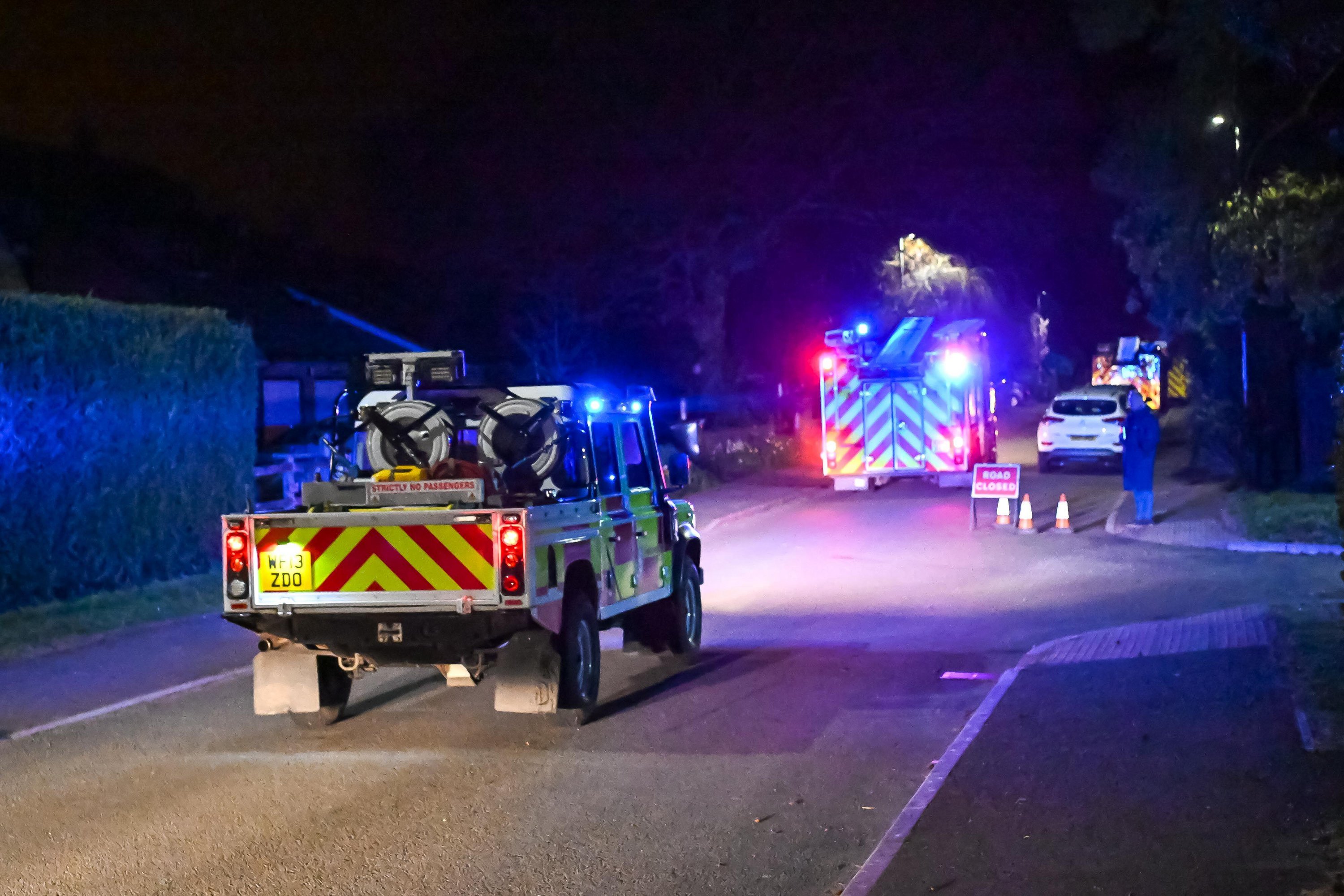 Fire engines responding to a wildfire at night.