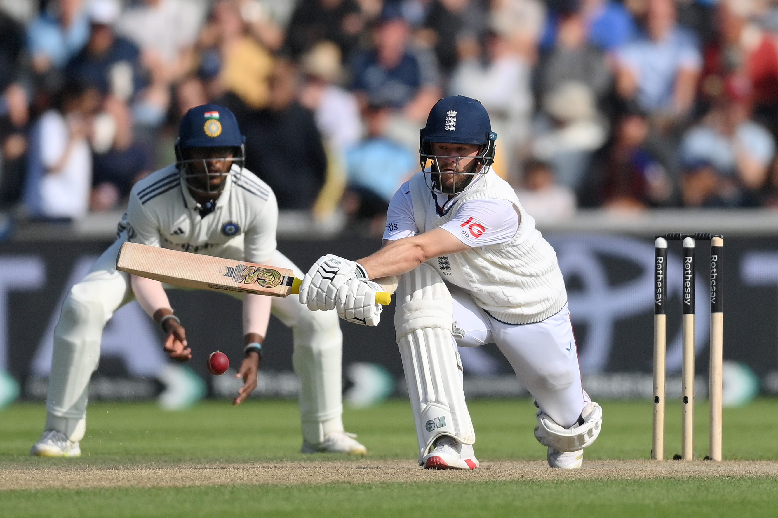 Ben Duckett of England reverse sweeps during a cricket match.