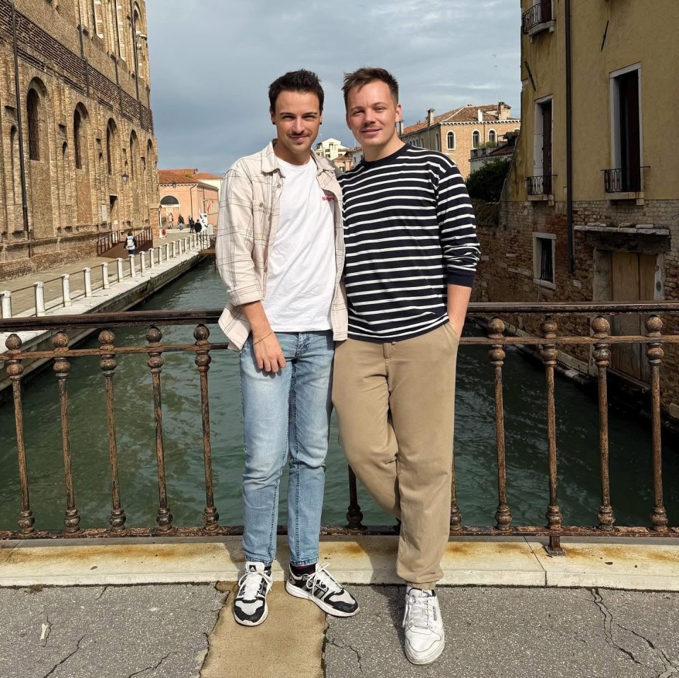 Two men posing on a bridge in Venice.