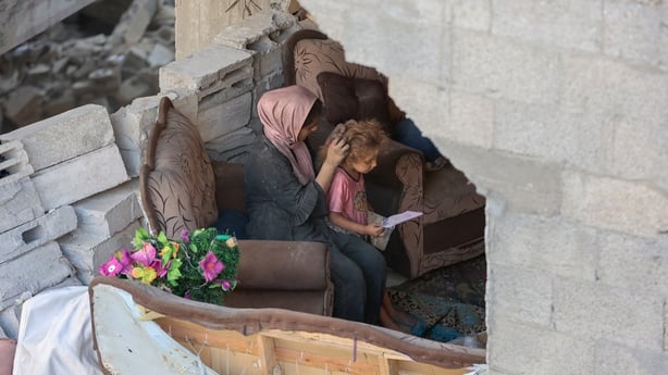 Palestinian mother and daughter seen in dmaaged building in Gaza