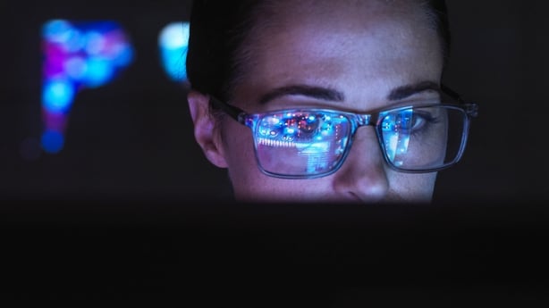 Female Engineer designing AI technology with reflection on eyeglasses