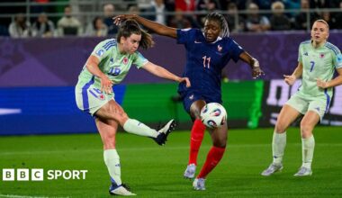 Esther Morgan kicking the ball against France
