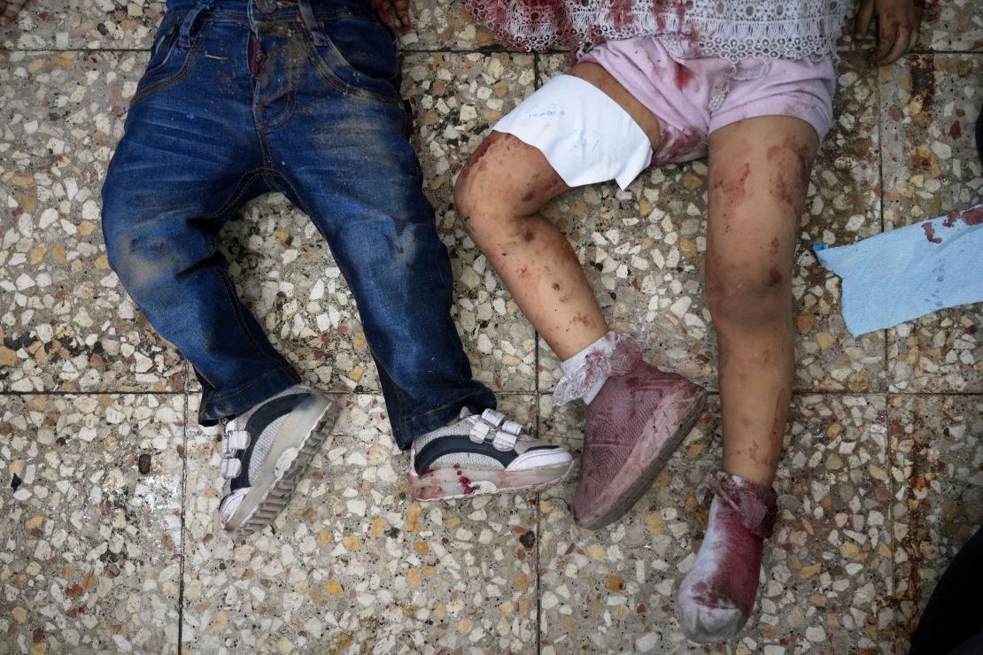 The bodies of two children lie on the floor of Aqsa Martyrs Hospital in Deir Al Balah on Thursday.