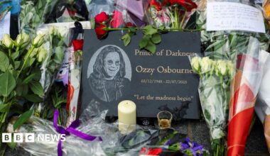 Flower tributes for Ozzy Osbourne in front a plaque that says Prince of Darkness, Ozzy Osbourne.